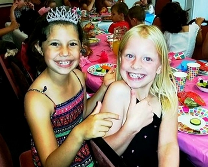 Two children smiling at a real birthday party