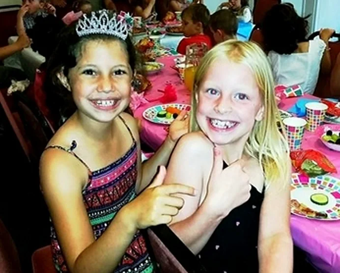 Two children smiling at a real birthday party
