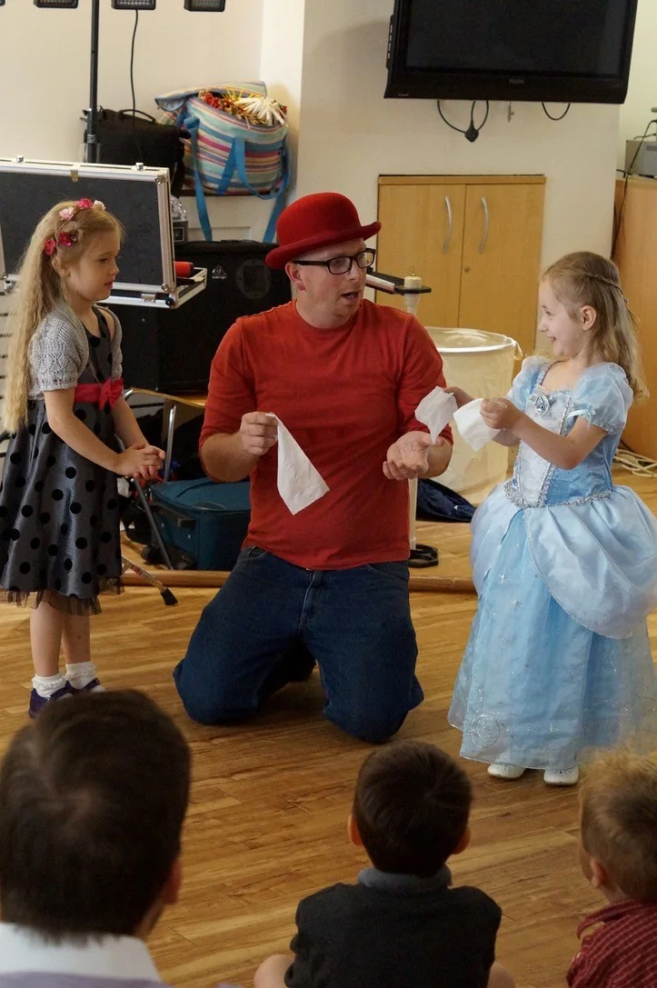 Benny Balloon performing an interactive magic routine with two children