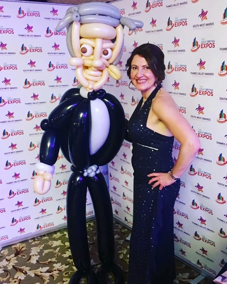 A guest beside an elaborate life-size balloon figure