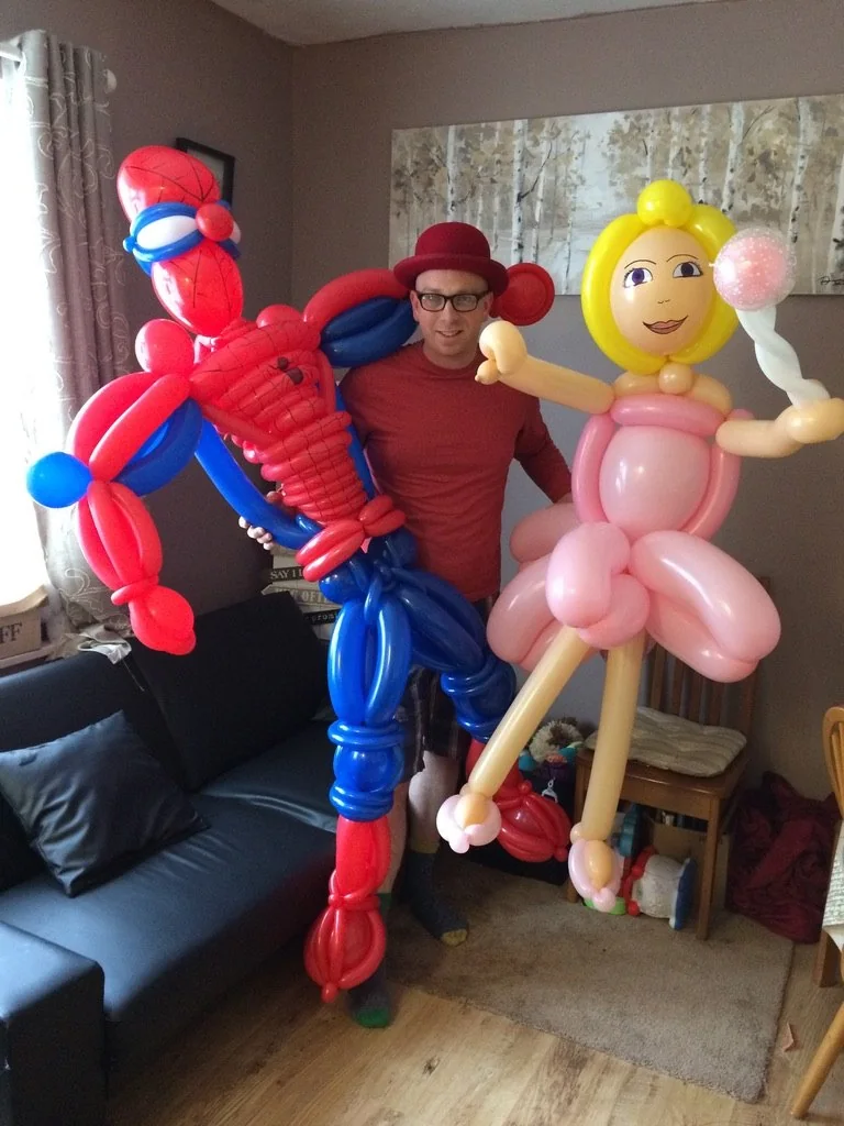 Benny with two large colourful balloon character creations