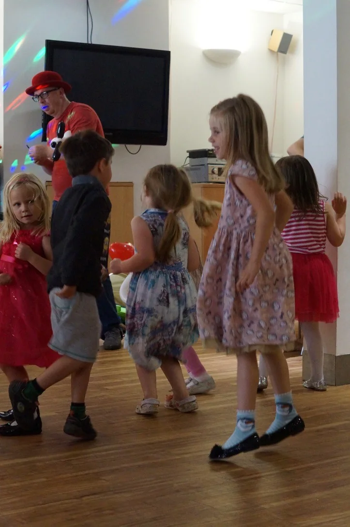 Children smiling and dancing together at a real birthday party