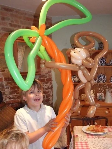 A child laughing with a giant balloon creation